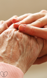 Close-up of a caregiver holding an elderly person's hand, providing support for dementia-related challenges.