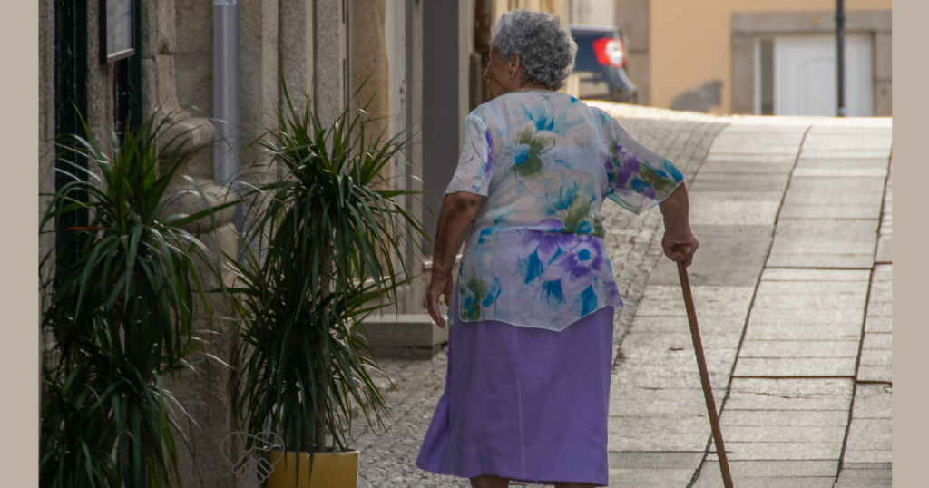 An elderly woman with dementia walking restlessly in a living room, illustrating the urge to walk and wandering.