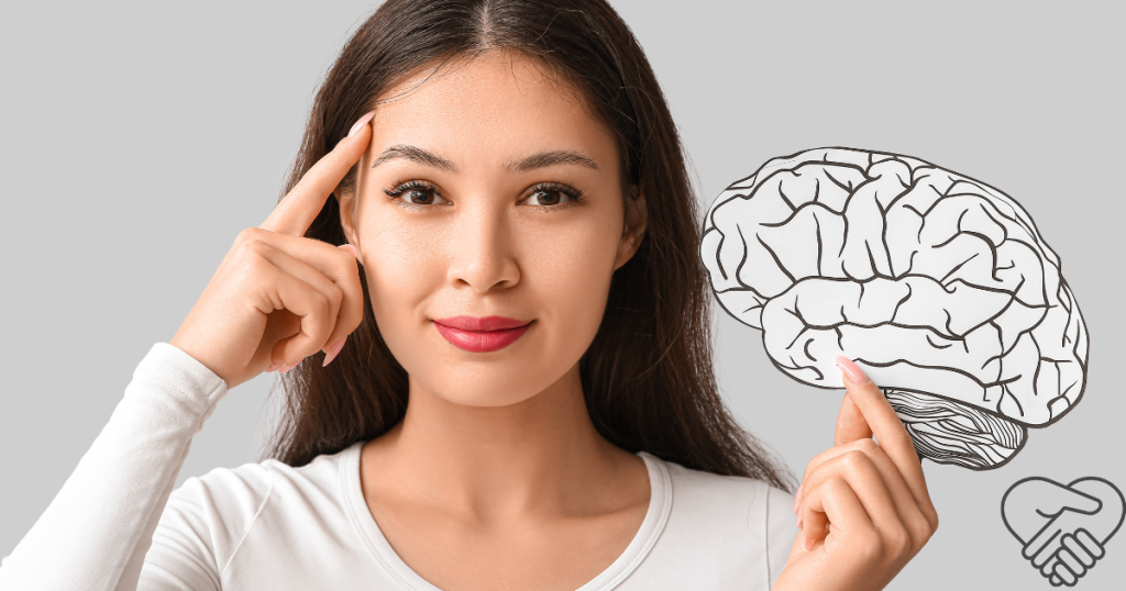 A smiling young woman pointing to her head with one hand while holding a graphic illustration of a human brain in the other. Illustration for brain health and anti-inflammatory diet.