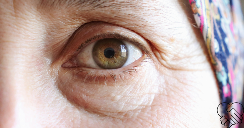 Extreme close-up of a woman's face, looking directly into the camera with fear and anxiety in her eye.