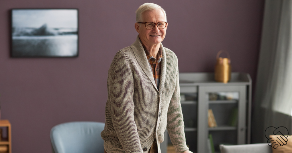 A happy senior man with memory loss smiling warmly while using a rolling walker in a bright, safe, and modern living room.