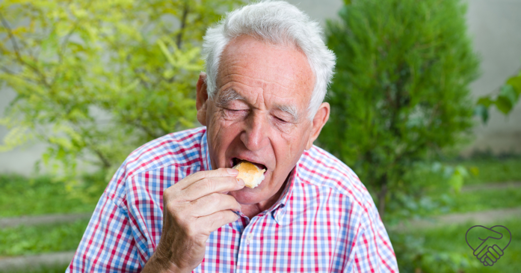 n elderly person sitting on a park bench, enjoying a small bite-sized piece of finger food