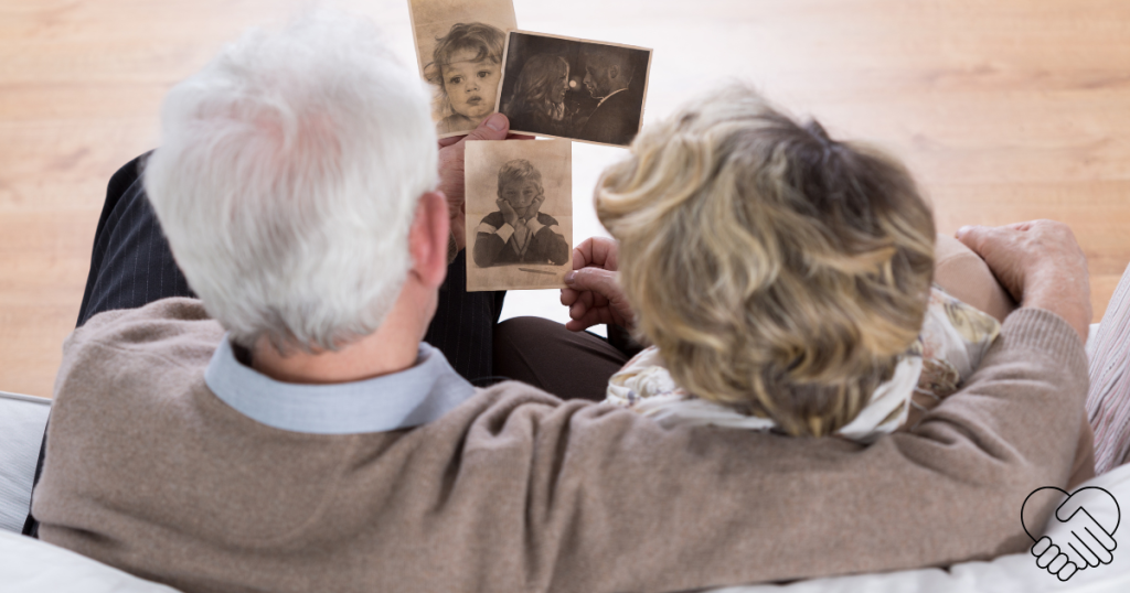 High-angle shot of an elderly couple sitting together at home, warmly and peacefully looking through an old photo album.