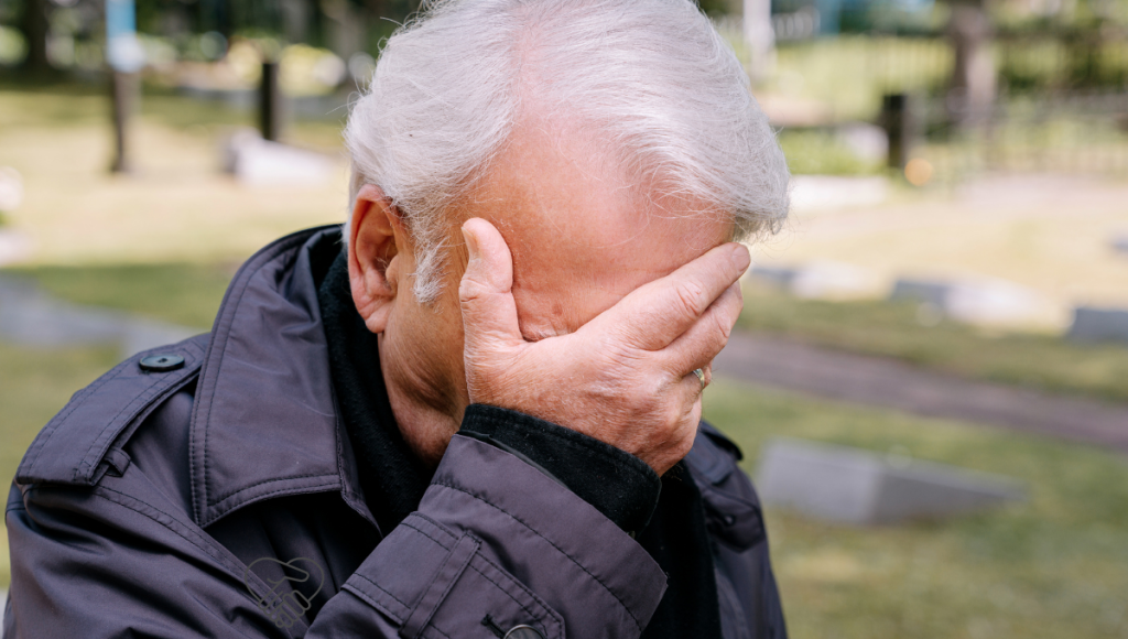 Silent Cry for Help: Recognizing Pain in Your Loved One with Dementia A close-up photo of an elderly man holding his head in pain.